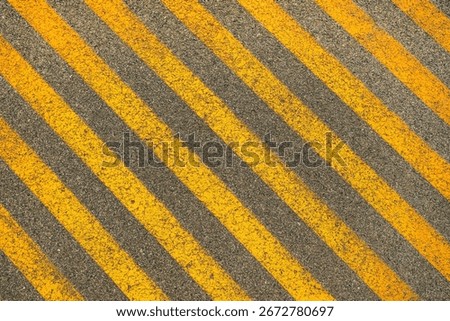 Yellow stripe pattern on asphalt parking lot space for person with disability, top view as background