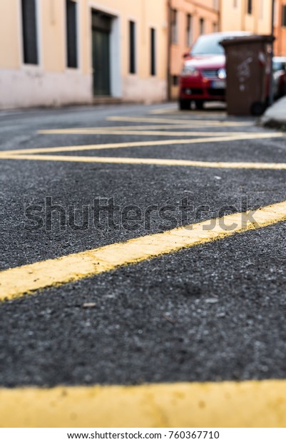 Yellow stripes on\
the black road Padua\
Italy