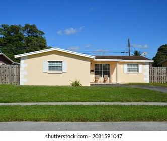 Yellow Suburban Snout Style Home On Sunny Day In Residential Neighborhood Florida USA