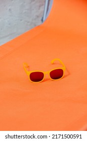 Yellow Sunglasses On Orange Sunbed