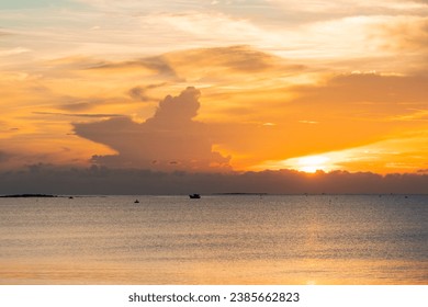 Yellow sunrise on the beach with cloudy sky. Sunrise and sunset at sea.
