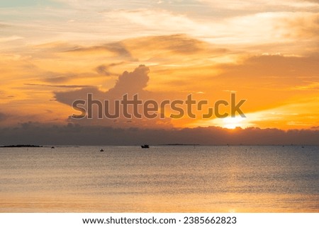 Yellow sunrise on the beach with cloudy sky. Sunrise and sunset at sea.
