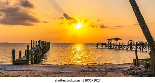 Yellow Sunset Over Indian River, Florida. View From The A1A Highway. Private Wooden Piers On The Coast As A Typical View Of The Rivers Of Florida