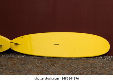 Yellow Surfboard On A Red Wall