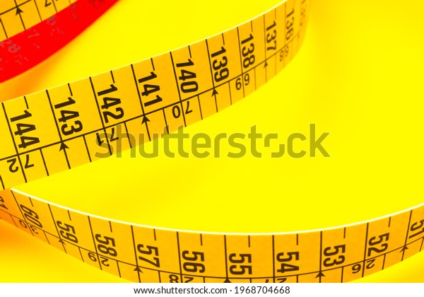 Yellow\
tape measure for measuring perimeters of objects; tailor\'s and\
dressmaker\'s tape for taking body\
measurements.