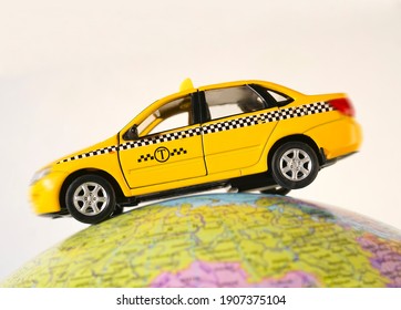  yellow taxi car - metal toy model - on globe  isolated on white  background. empty copy space for inscription. 