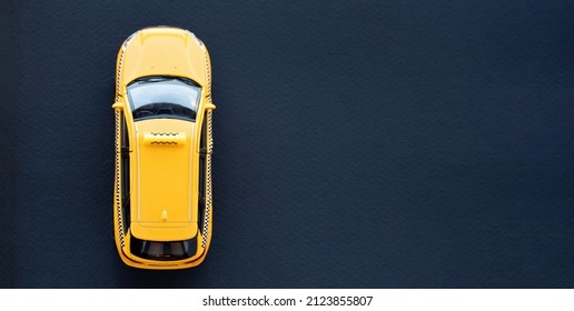 Yellow Taxi Car Top View On A Black Background Macro Photography. Taxi Service Advertising Banner. Car Rental Concept.