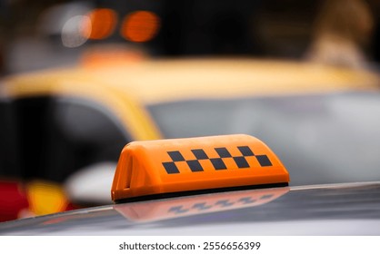 Yellow taxi with an orange light top at a busy city street during the day. Brightly colored taxi with an orange topped light is parked near other taxis in a bustling urban environment. - Powered by Shutterstock