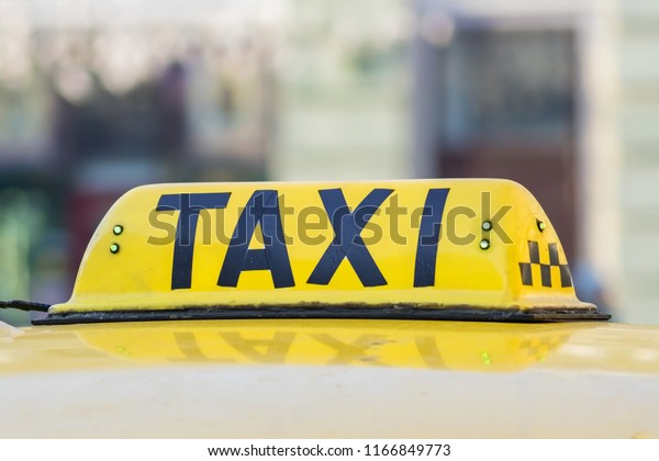 Yellow taxi sign. Taxi\
car on the street