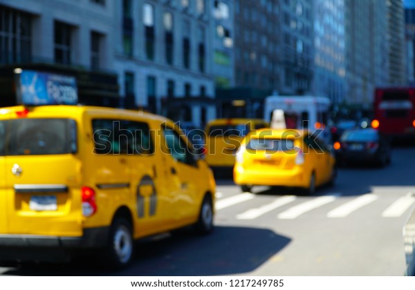 Yellow taxis in the streets of Manhattan, New York City,\
USA. Busy city life blurred with taxi in foreground.               \
               