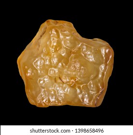 Yellow Tektite Specimen Isolated On Black Background Close-up. Libyan Desert Glass 