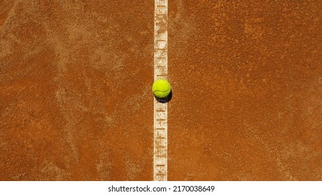  A yellow tennis ball lies on the clay court.  - Shutterstock ID 2170038649