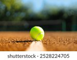 Yellow tennis ball on white strip marked court outdoor summer ground closeup. Sport game leisure activity equipment sportive competition championship match playing exercising at sunny arena