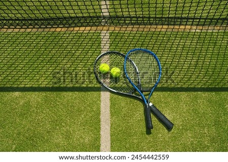 A yellow tennis ball and tennis racket lies on the clay court.