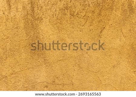 Yellow textured plaster wall surface with rough grain.