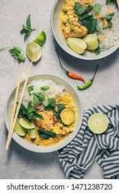 Yellow Thai curry with white basmati rice in a large bowl with lots of vegetables, lime, chili peppers very spicy food 