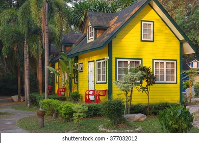 Yellow tiny wooden house with white windows