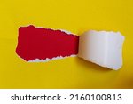 Yellow torn paper on red background. Top view of torn paper with space for text.