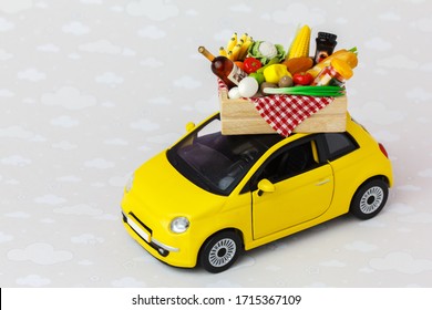 A Yellow Toy Car Delivering Food, Drinks And Grocery. Online Food  Shopping Or Donation Concept.