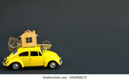 Yellow Toy Car With A Key To The House On The Roof On A Black Background. Moving To A New House, Mortgage, Buying An Apartment, Taxi. Copy Space. April 8, 2021, Kaluga, Russia