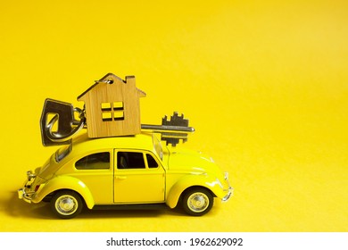 Yellow Toy Car With A Key To The House On The Roof On A Color Background. Moving To A New Home, Mortgage, Buying An Apartment, Taxi. Copy Space. Kaluga, Russia, April 8, 2021