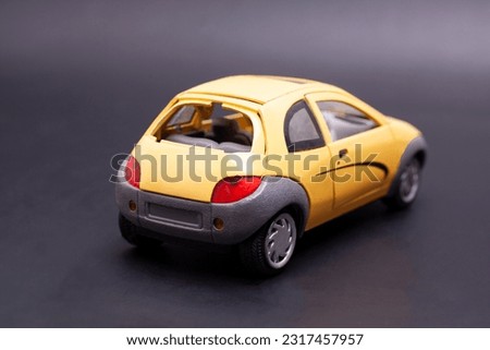 Yellow toy car on black background.