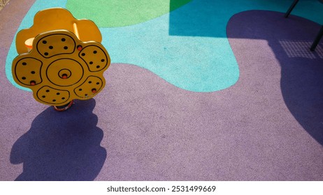 Yellow toy car on a green and brown playground. yellow toy sun flower on a purple and blue playground - Powered by Shutterstock