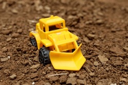 Yellow Toy Construction Car On The Ground. Children's Game. Toy Car. Close Up