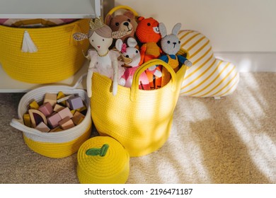 Yellow Toy Storage Baskets In The Children's Room. Cloth Stylish Baskets With Toys. Organizing And Storage Ideas In Nursery. Clean Up Toys And  Reduce The Clutter.