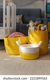 Yellow Toy Storage Baskets In The Children's Room. Cloth Stylish Baskets With Toys. Organizing And Storage Ideas In Nursery. Clean Up Toys And  Reduce The Clutter.