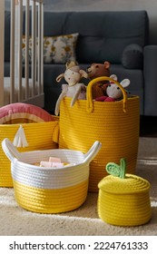 Yellow Toy Storage Baskets In The Children's Room. Cloth Stylish Baskets With Toys. Organizing And Storage Ideas In Nursery. Clean Up Toys And  Reduce The Clutter.