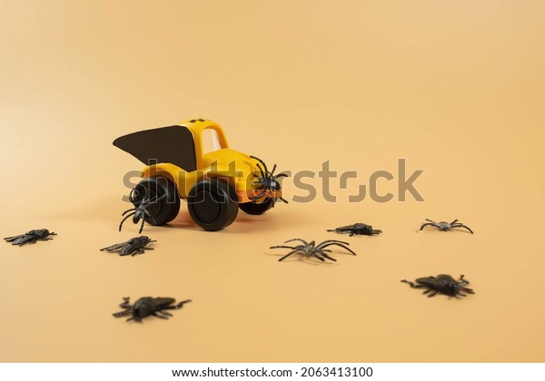 Yellow\
toy taxi car with bat wings in Halloween costume and scary on beige\
background background. Flower delivery,\
children.