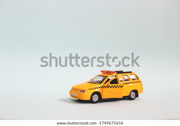 Yellow toy taxi car model. idea, symbol, concept\
of urban service and delivery. Copy space. Mobile online\
application concept.