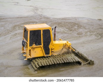 Yellow Tractor Cleaning The Drained Pond From Dirt And Debris.Remove Silt Ground