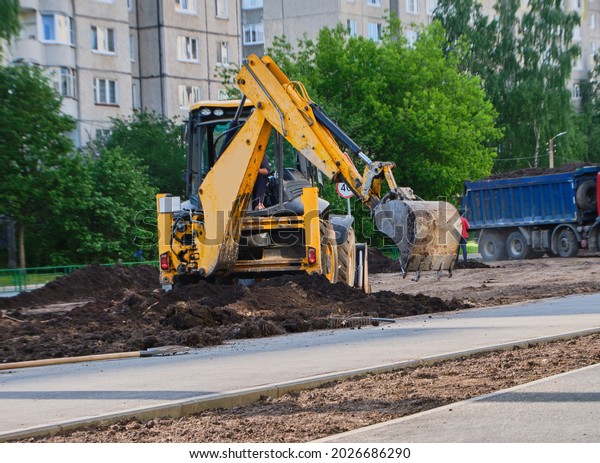 Yellow tractor repairs the road. Russia, Vladimir,\
02.06.2021. Road works in the city. Industrial Equipment. High\
quality photo