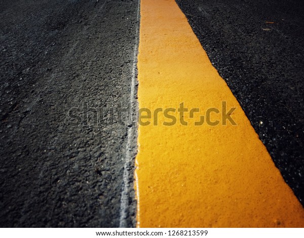 Yellow traffic paint on the\
road.