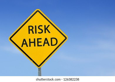 Yellow traffic sign "Risk Ahead" on the sky background