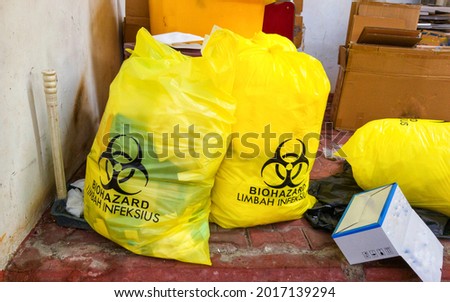 yellow trash bag of biohazard medical waste. Word limbah infeksius in Indonesian means  infectious waste