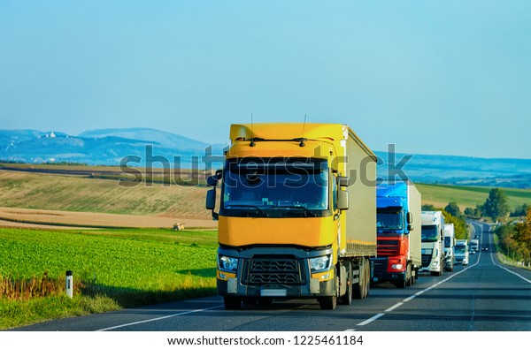 Yellow Truck in the alphalt road of\
Poland. Lorry transport delivering some freight\
cargo.