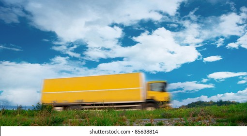 Yellow Truck In Blurred Motion In Rural Landscape