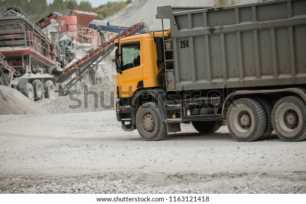yellow truck. loaded with\
coal. sunny weather. kamaz bears a white breed. coal mine. extract\
cement\
