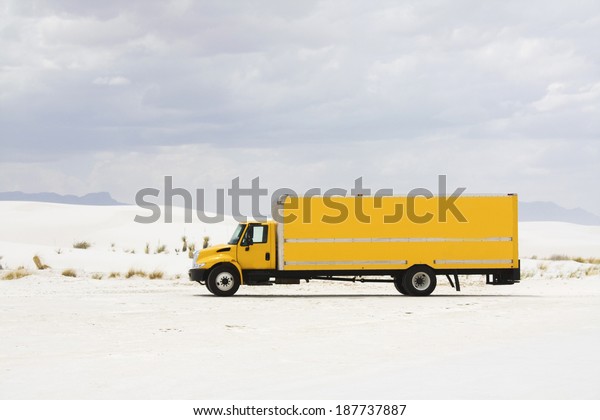 Yellow truck\
in White Sand Dunes NM - New\
Mexico.