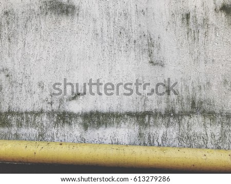 Yellow tube against old wall