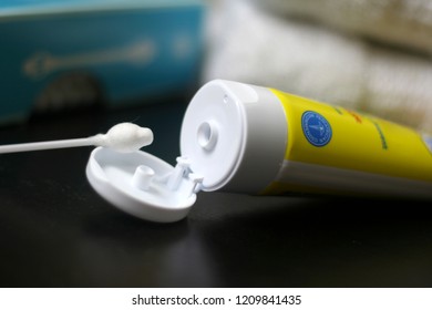 Yellow Tube Of Diaper Rash Cream With Aqua Q-tip Box And White Towels