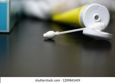 Yellow Tube Of Diaper Rash Cream With Aqua Q-tip Box And White Towels