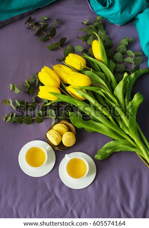 yellow tulips, cookies and two cups of tea in bed