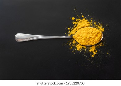 Yellow turmeric slide is in the metal spoon . Black background. Spice. Seasoning for dishes. - Powered by Shutterstock