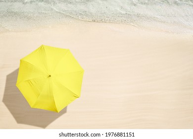 Yellow umbrella on tropical sand beach. Top and aerial view. Ocean coastline. Drone photo. Background 