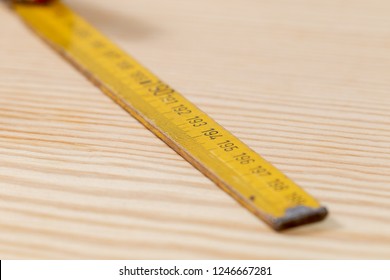 Yellow used yardstick on wooden background
