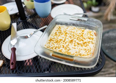 Yellow Vanilla Cream Dessert Homemade Carrot Cake On Outdoor Metal Table With Bee Pollen Decorations And Empty Plate Above View